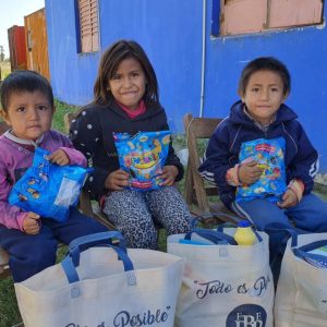 Tre barn från Argentina med godis och matpaket de fått från Hoppets stjärna.