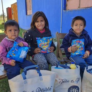 Tre barn från Argentina med godis och matpaket de fått från Hoppets stjärna.