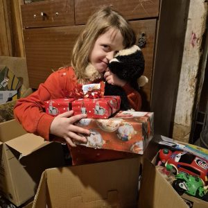 En flicka från balvi, Lettland som fått julklappar och matpaket från Hoppets stjärna.