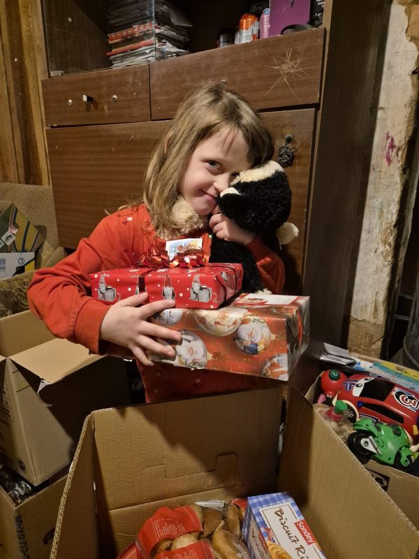 En flicka från balvi, Lettland som fått julklappar och matpaket från Hoppets stjärna.