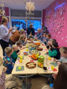 En grupp barn i balvi Lettland som äter smörgåsar, frukt och dricker saft.