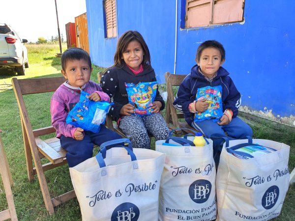 Tre barn från Argentina med godis och matpaket de fått från Hoppets stjärna.