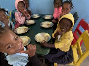 en grupp barn från Haiti som är glada och äter lunch.