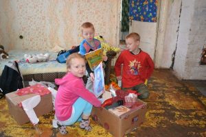 En grupp barn från balvi som öppnar varudonationer från Hoppets stjärna.
