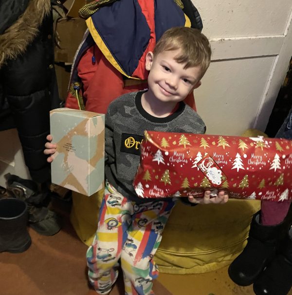 En pojke som håller upp två julklappar.